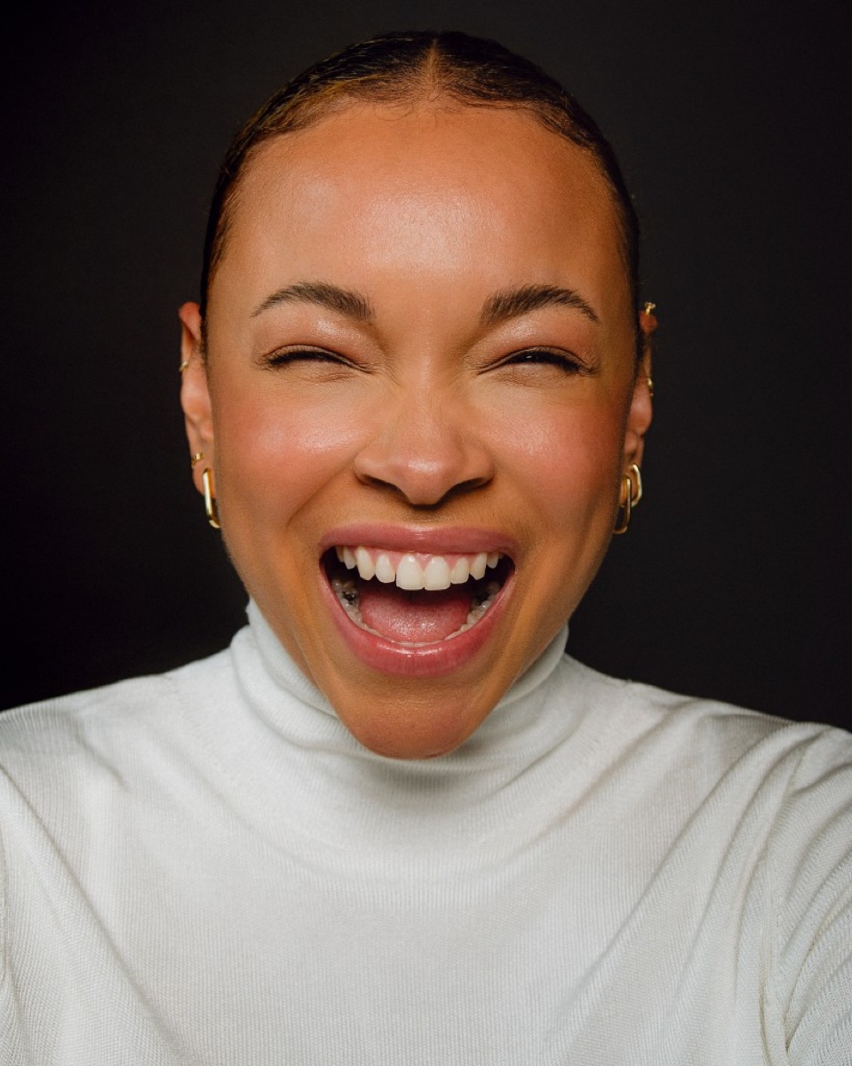 FEE laughing in a white turtleneck beauty shot